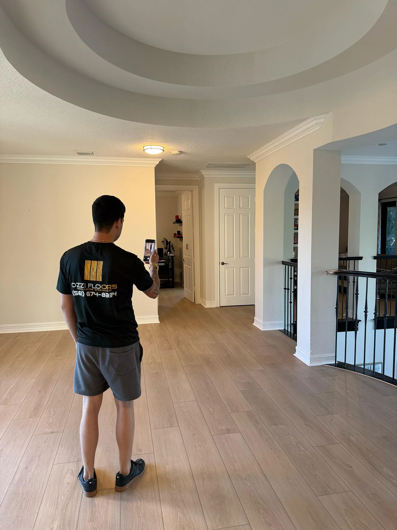 Someone from Ozzifloors photographing a finished upstairs landing laid in warm oak-look plank